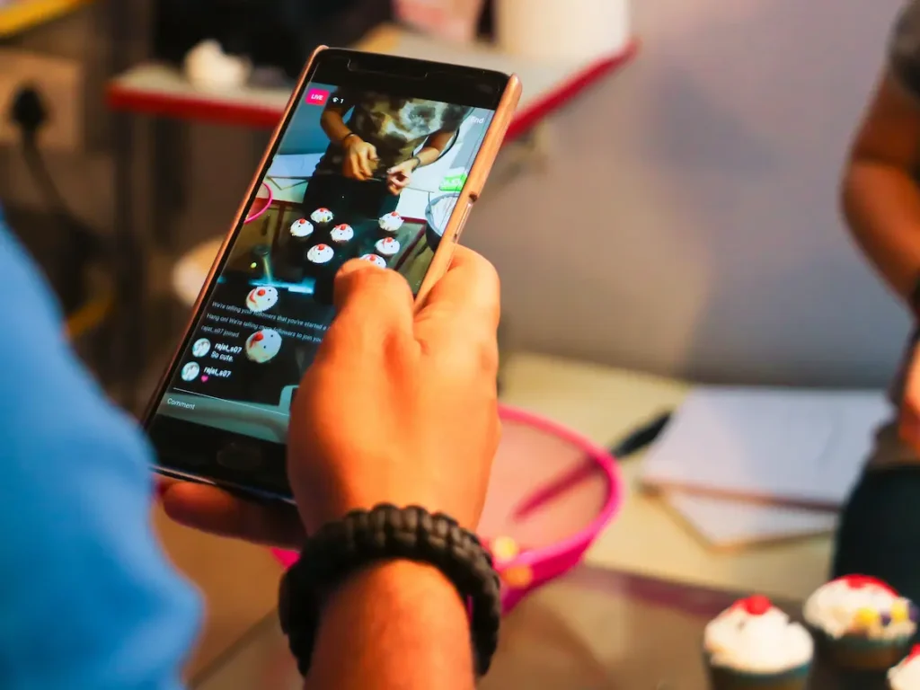 OnlyFans Management Services: Person recording a live stream on social media from their smartphone showing baking content