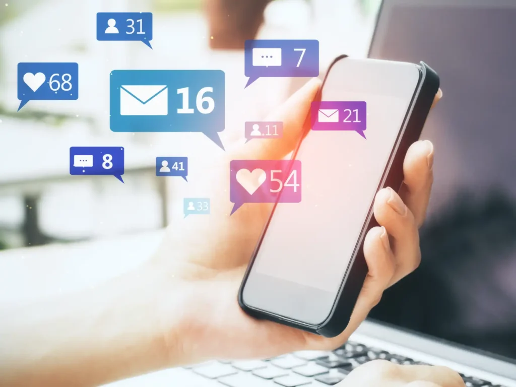 OnlyFans Management Services: Hand holding a smartphone with floating notification icons for likes, messages and followers